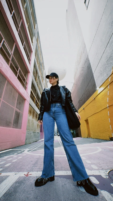 woman standing in the middle of a wide - leged city sidewalk