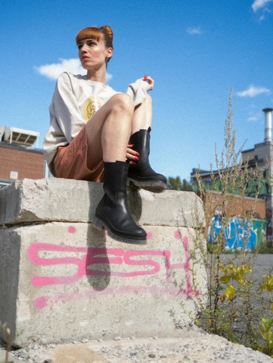 a boy sitting on top of a concrete wall