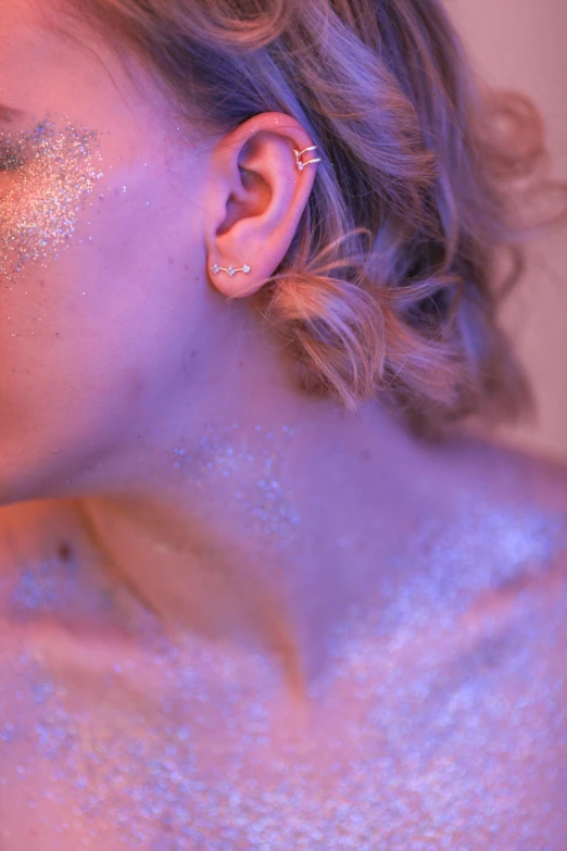 a beautiful blonde girl has gold glitter all over her face