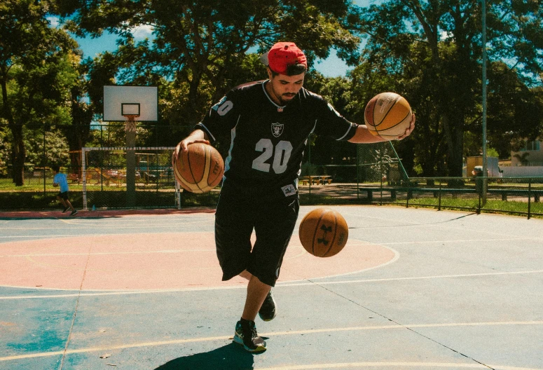 a young man is playing basketball in an outdoor court