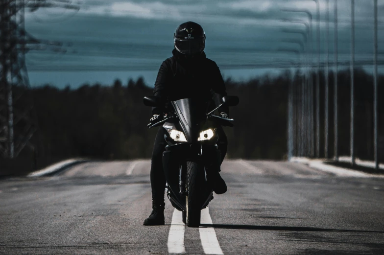 person in black jacket riding motor bike on road