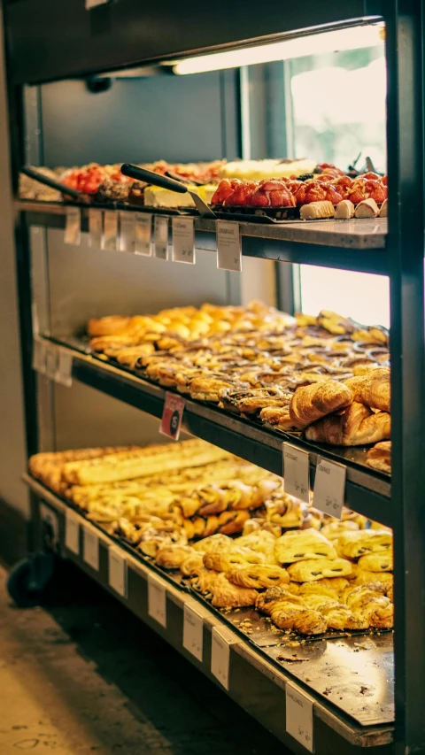 bakery display shelf of pastries and pies with one being baked