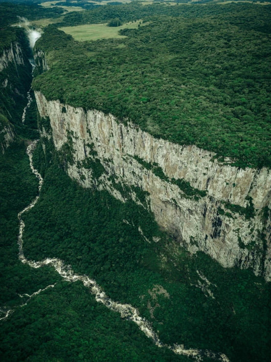 an aerial s of a steep area with a river flowing through the hillside