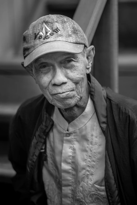 an elderly man wearing a hat in a black and white po