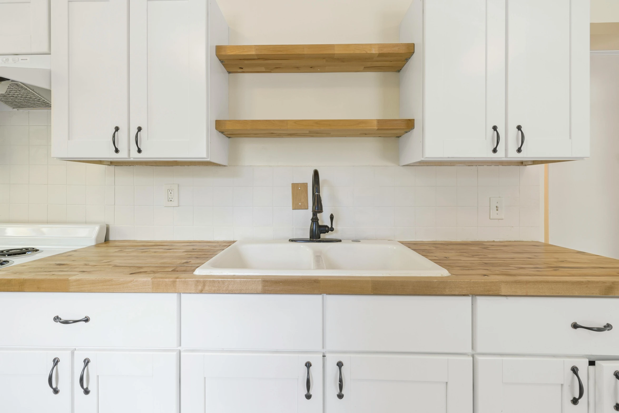 a white kitchen has wooden counter tops