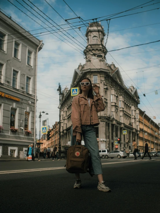 a woman is walking on the side of the street while using her cell phone