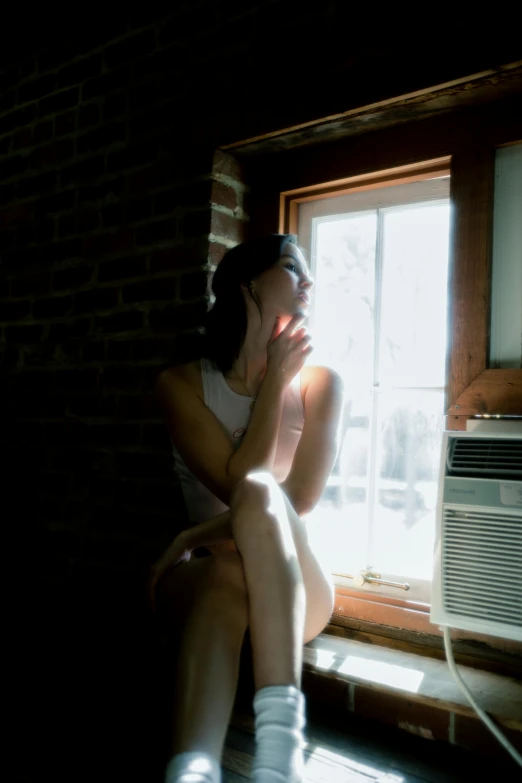 girl sitting on the window ledge in white boots looking out