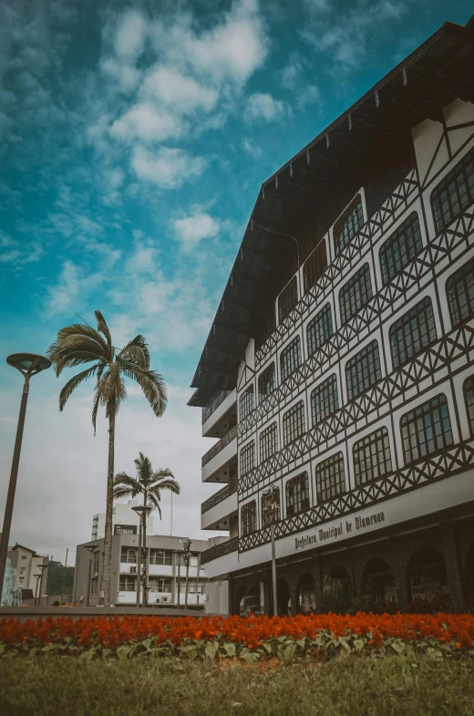 a tall white building with a brown and black balcony