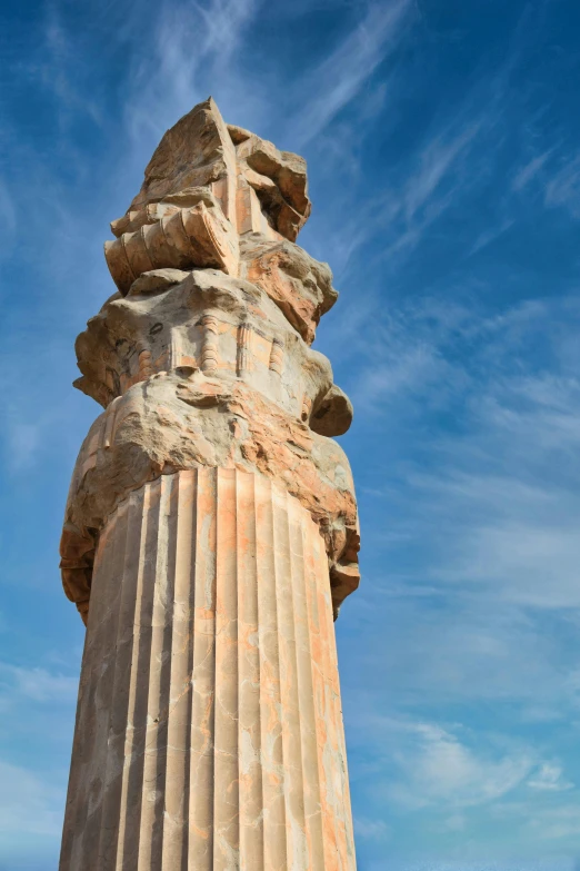 a pillar is seen against a partly cloudy sky