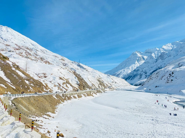 a large snowy mountain with people walking by it