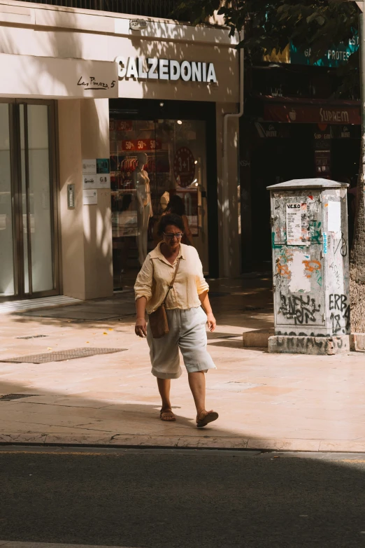 a man stands on a street corner in front of a store