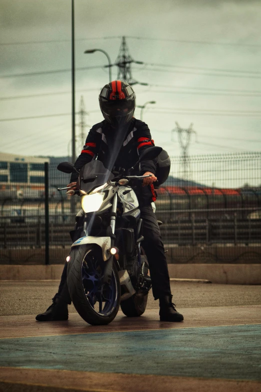 a man in a leather jacket sits on a motorcycle