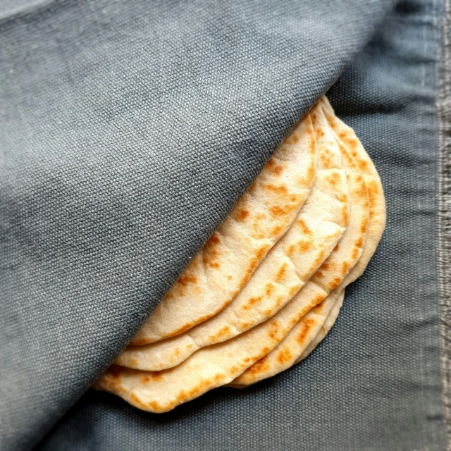 a flat piece of bread is hiding under the grey denim pocket