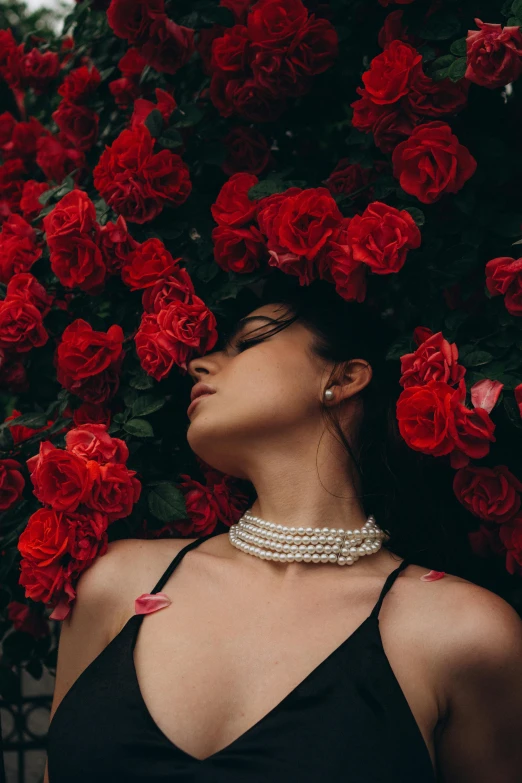 a woman is sitting in front of a bunch of roses