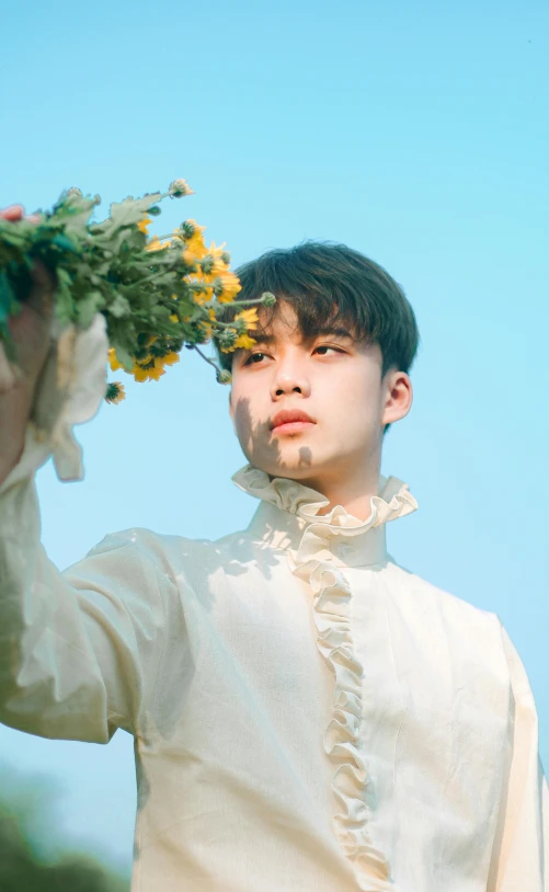 a  holding a bunch of flowers in his hands