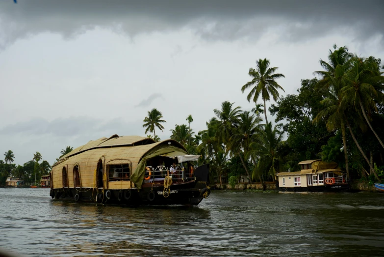 a small houseboat moving through a river near other houses