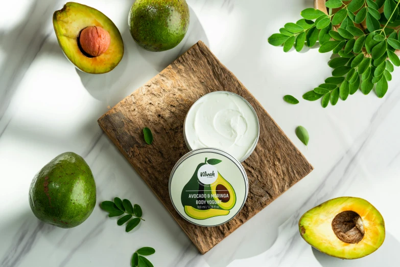 an avocado, lemon and yogurt sitting on top of a  board