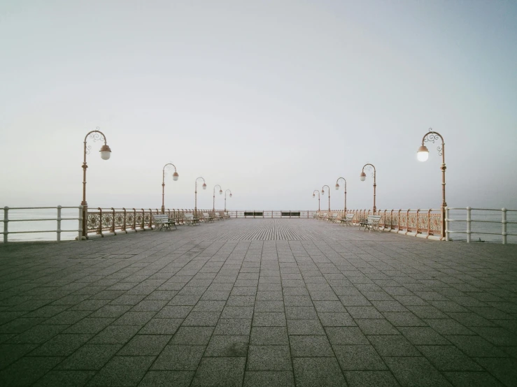 a long paved road lined with lamps and benches