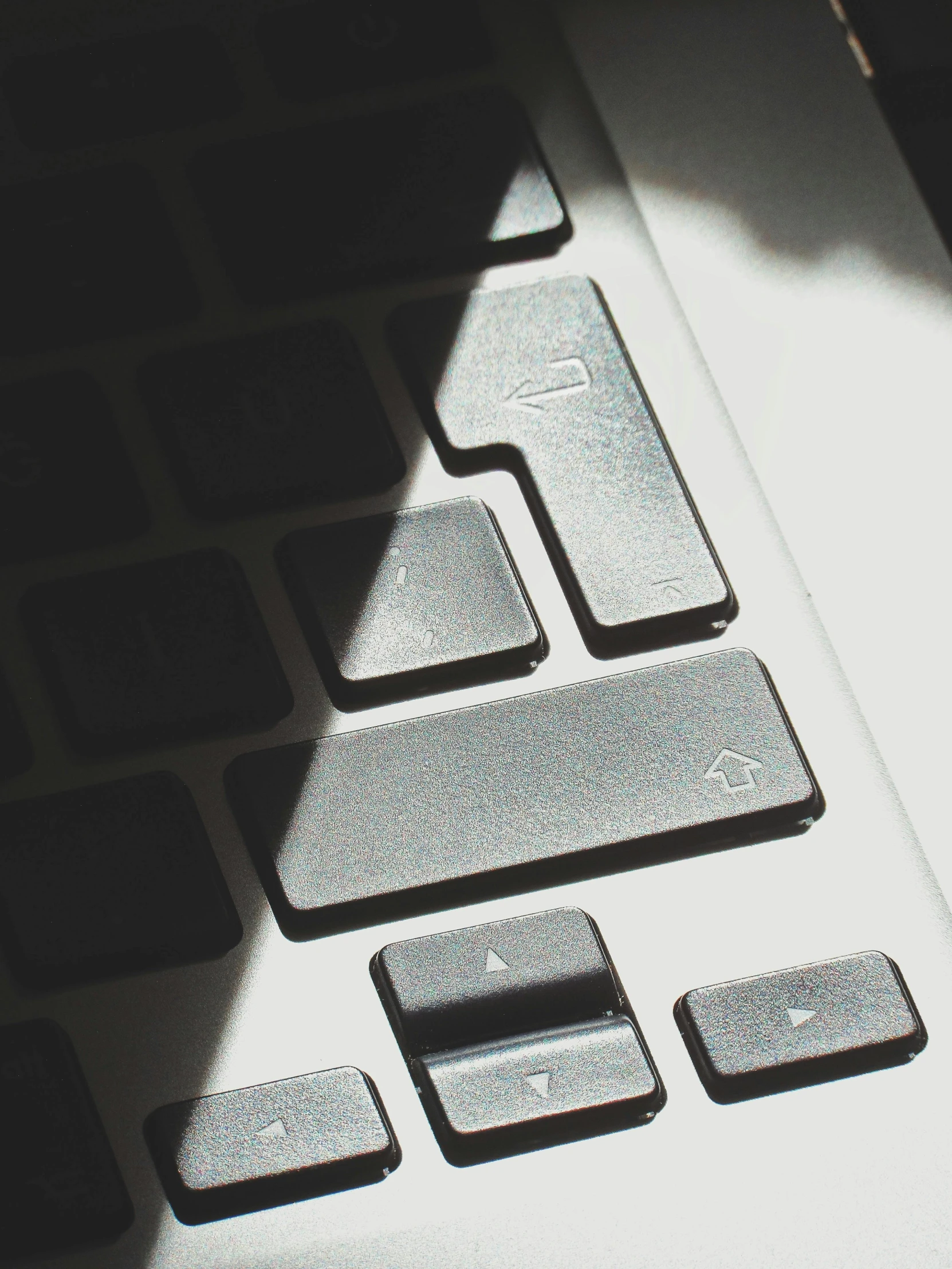 a computer keyboard with a light shadow on the side