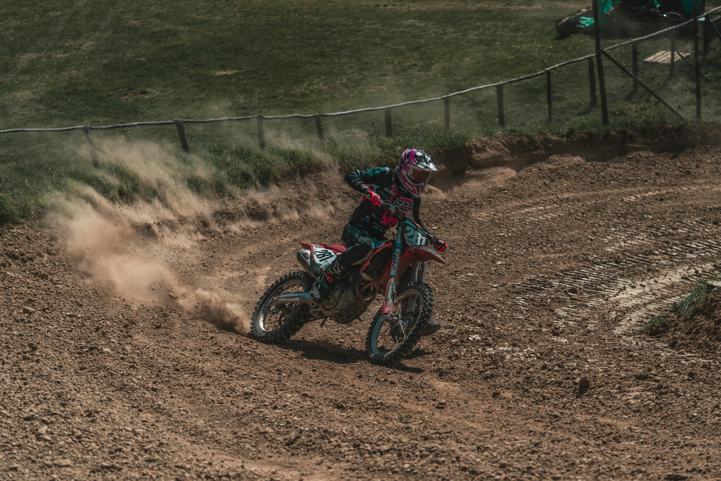 a motorcycle rider riding a dirt bike on top of a dirt track