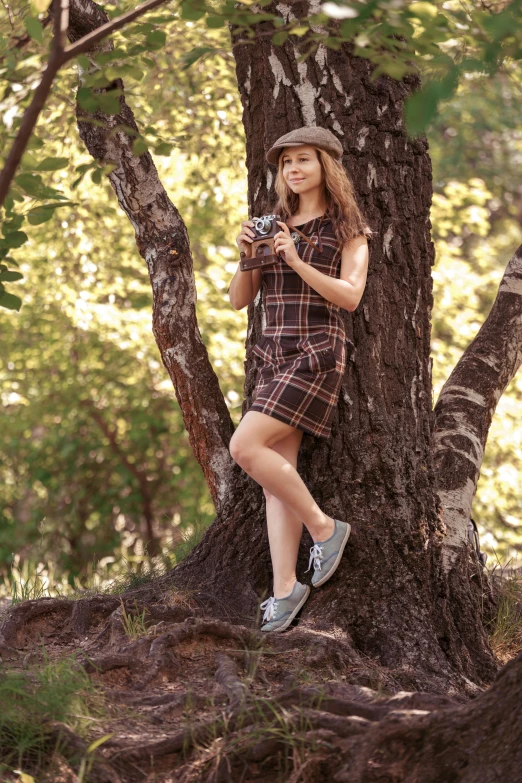a woman in plaid is standing on the side of a tree