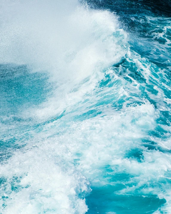 a wave crashing against the top of an ocean