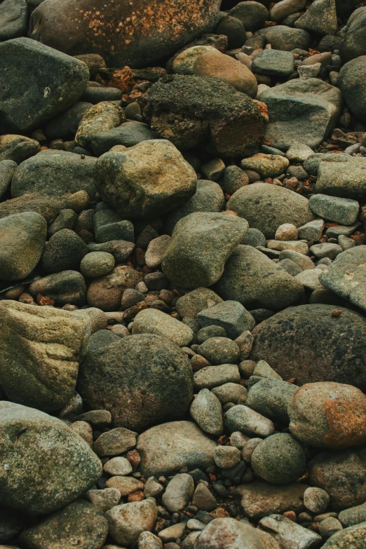 large rocks covered in moss and dirt next to the ocean