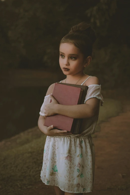 a  is holding a pink book