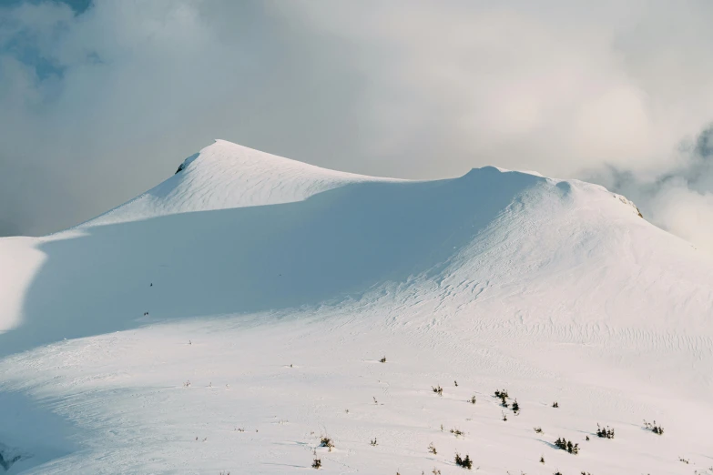 a ski slope covered in snow on a cloudy day