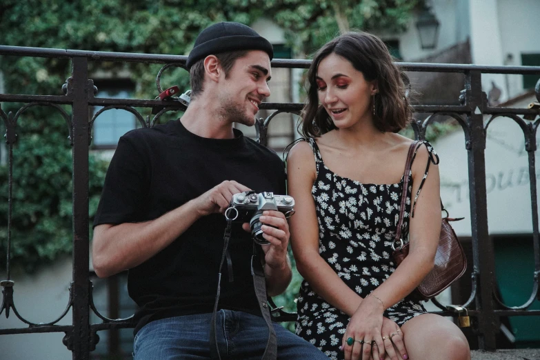 the woman is smiling at the man with his camera