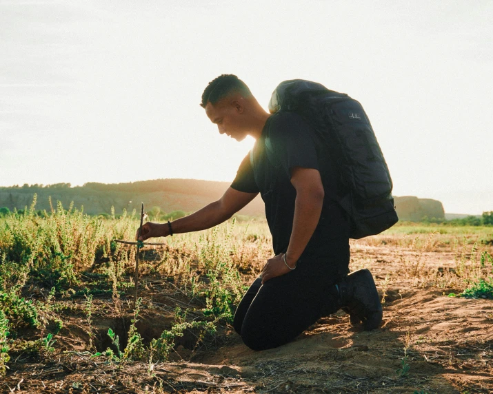 the young man is checking plants in the field