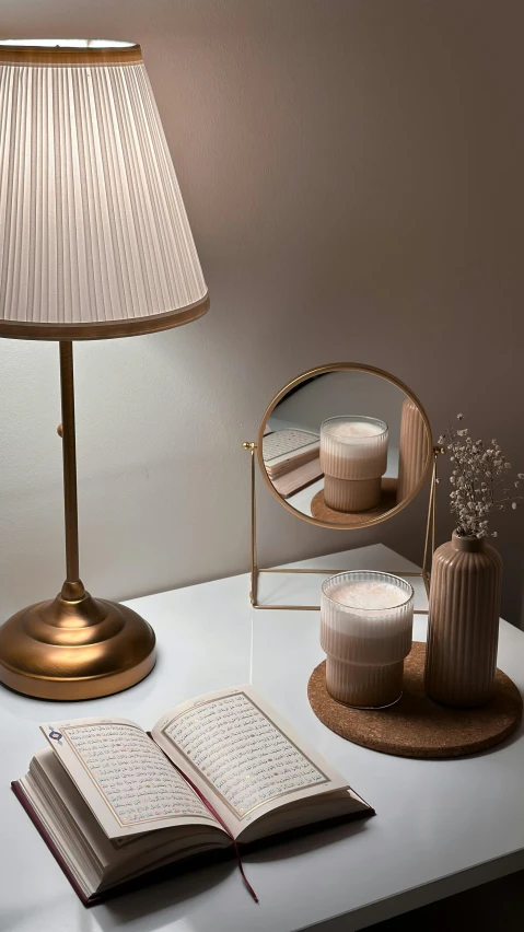 a lamp sitting on top of a table next to a book and vase