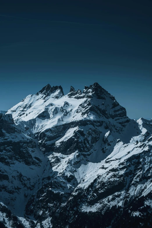 snow - covered mountains and hills under a clear blue sky