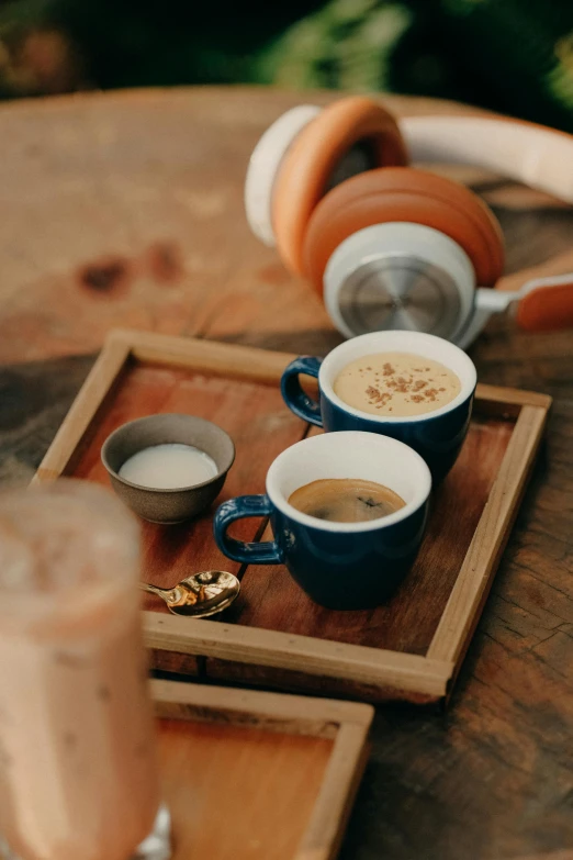 a couple cups of coffee sitting on top of a tray