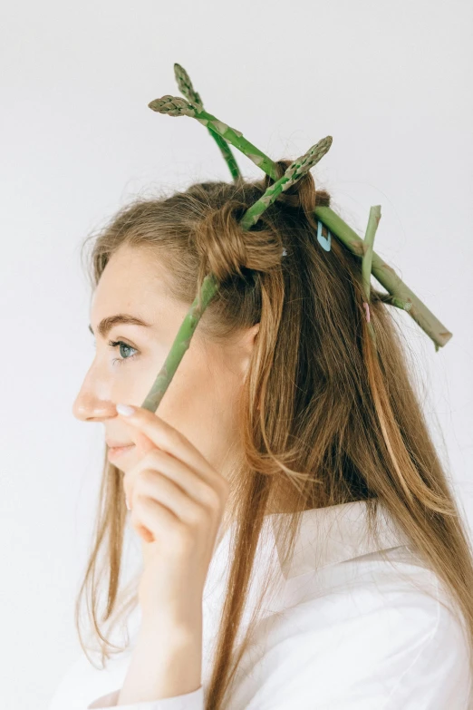 a woman holding a stick with plants on it