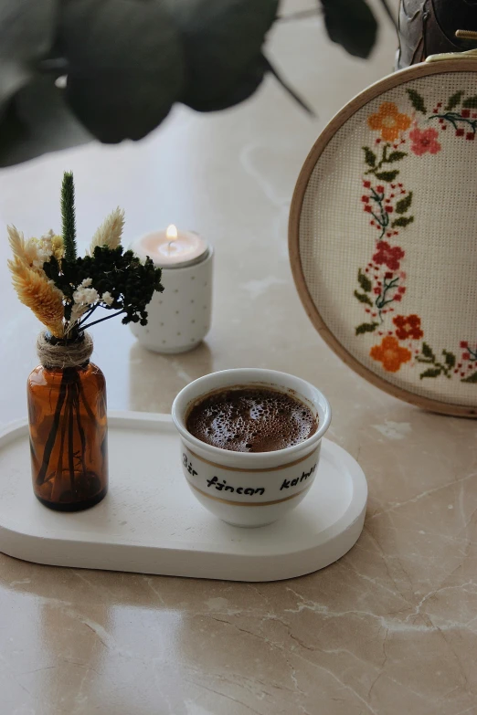 flowers and candle on tray on marble table