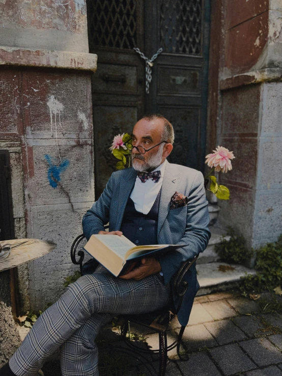 an old man sitting down reading a book