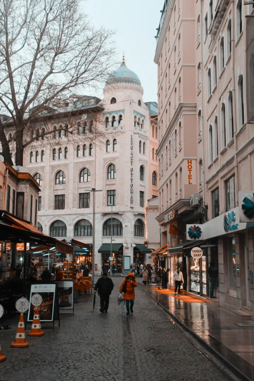 a very pretty building with a couple people walking down the street