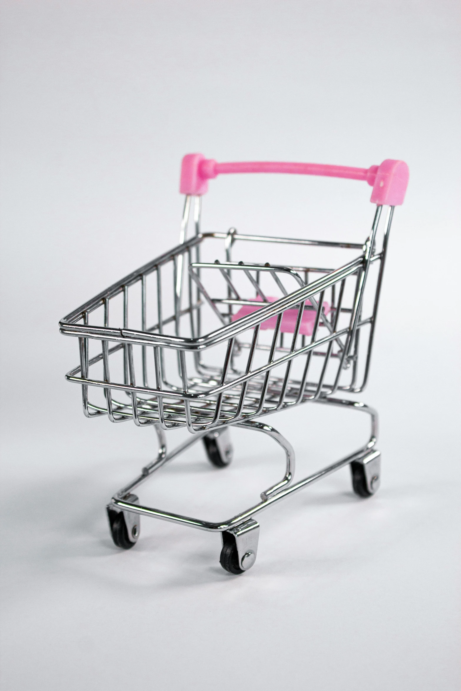 a pink shopping cart is sitting on the floor