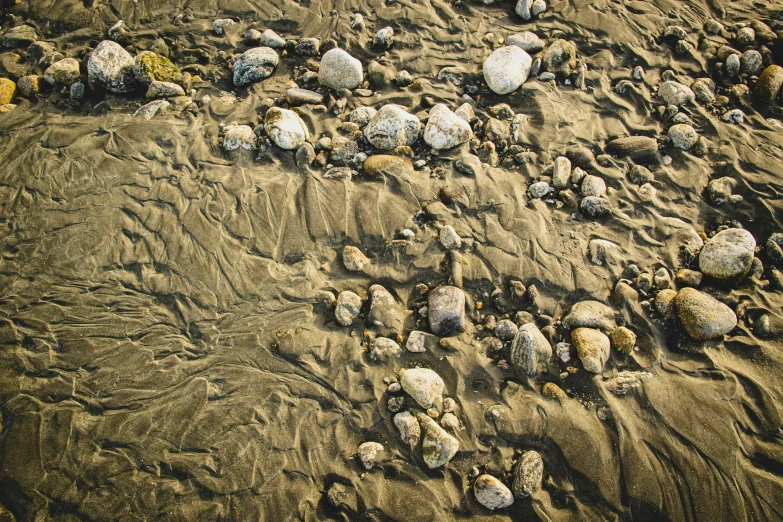 pebbles and rocks on sand with small waves