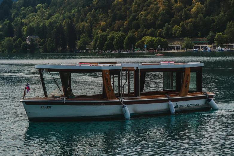 small boat on calm water with mountain in background