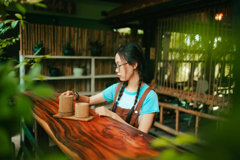 the woman is looking into her camera while sitting at the table