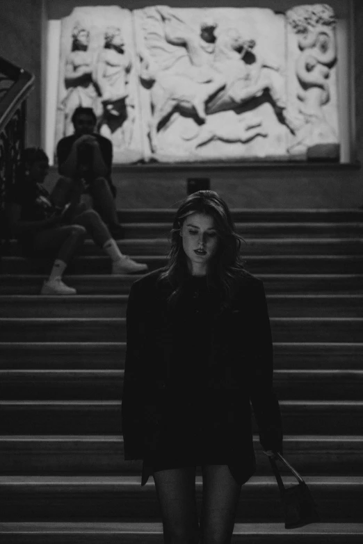 a black and white po of woman walking down the stairs