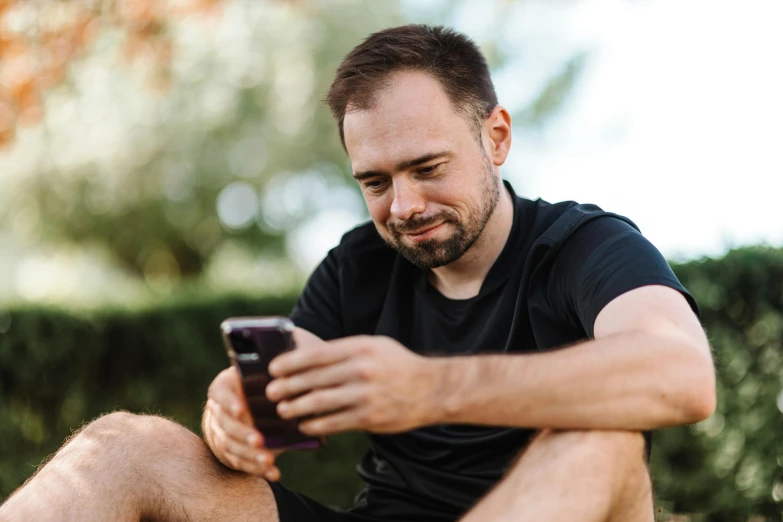 a man sitting down using a cell phone