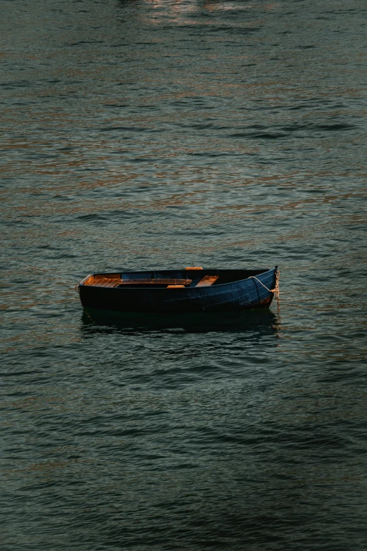 a boat floats in the water as another paddles out on the ocean