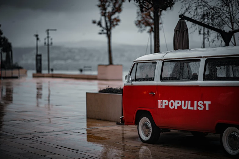 a red and white mini bus on a rainy day