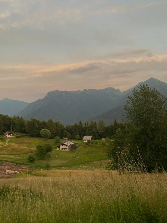 a beautiful landscape with houses, and mountains in the background