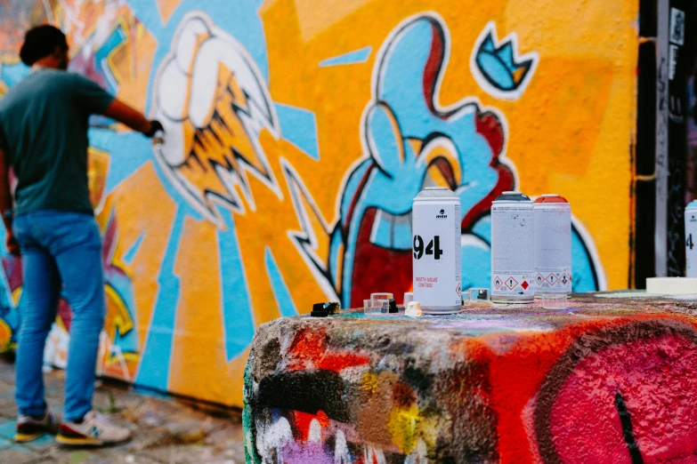 a man riding on the skateboard next to a colorful wall