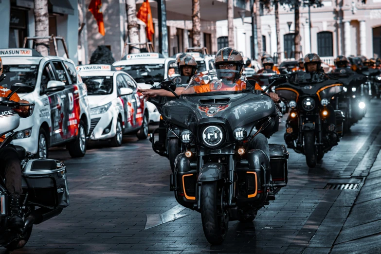 the group of motorcyclists are all traveling down the road