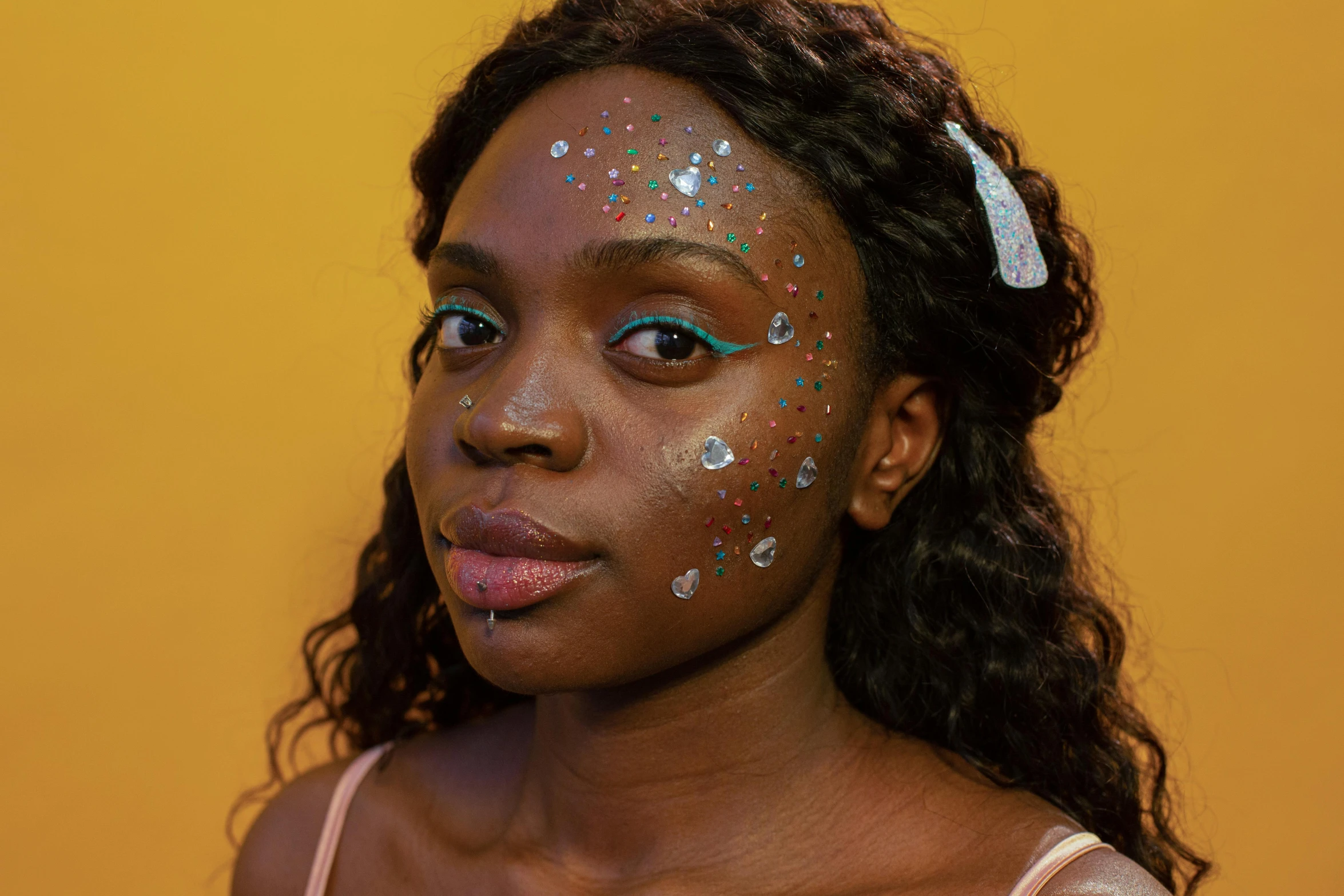 a woman with glitter on her face wearing a pink 